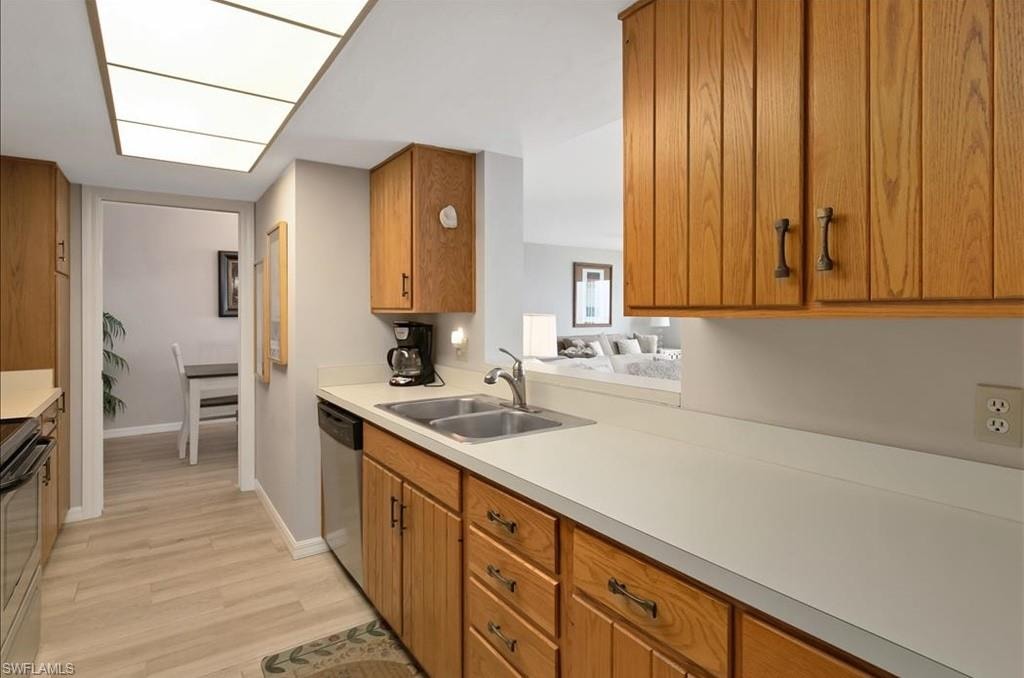Kitchen featuring light countertops, brown cabinetry, light wood-style floors, and appliances with stainless steel finishes