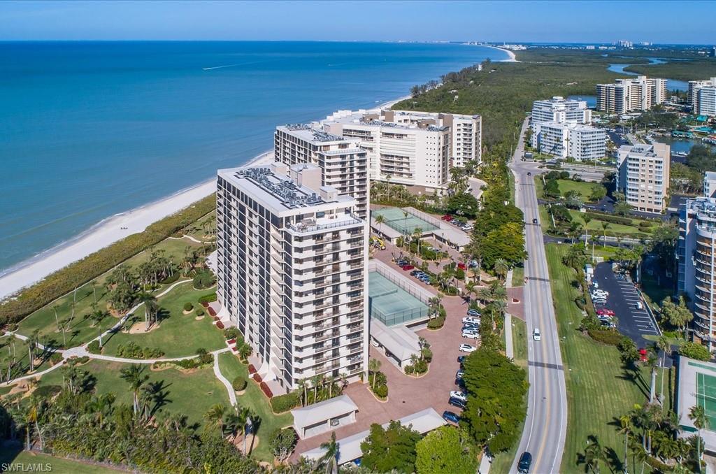 Aerial overview of property's location featuring waterfront with a beach and apartment complex / building