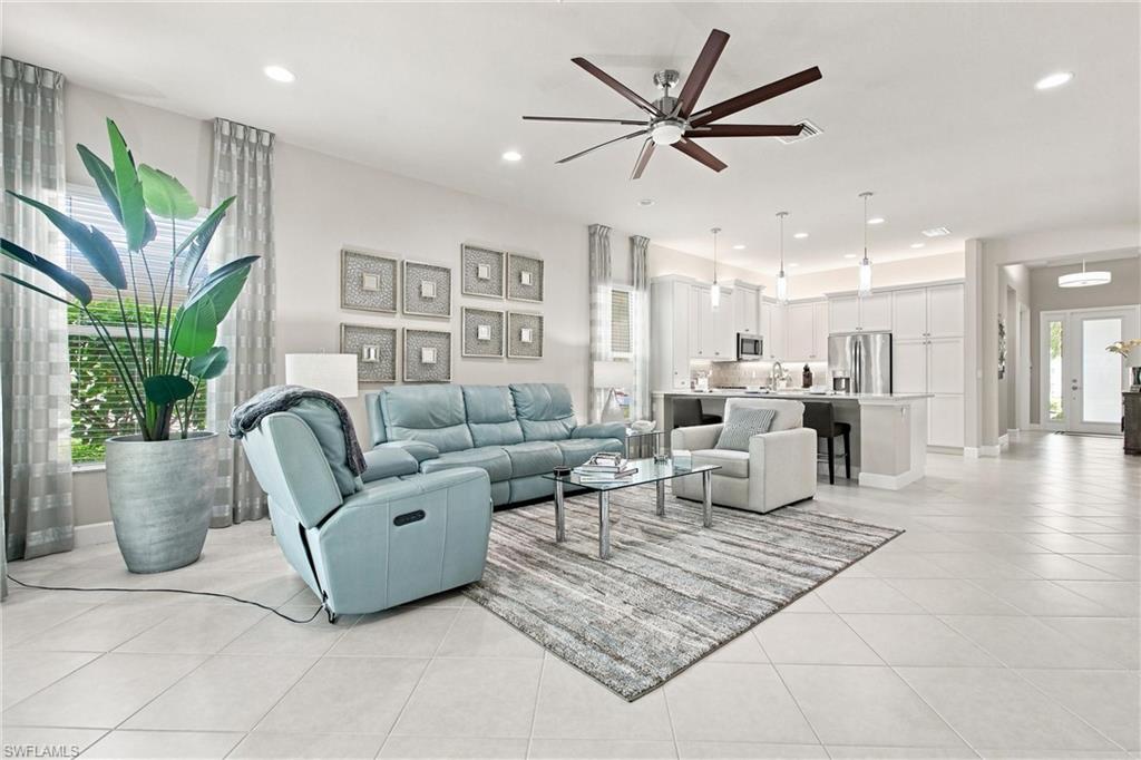 Open-concept living area featuring large format tile flooring, recessed lighting, and a contemporary ceiling fan
