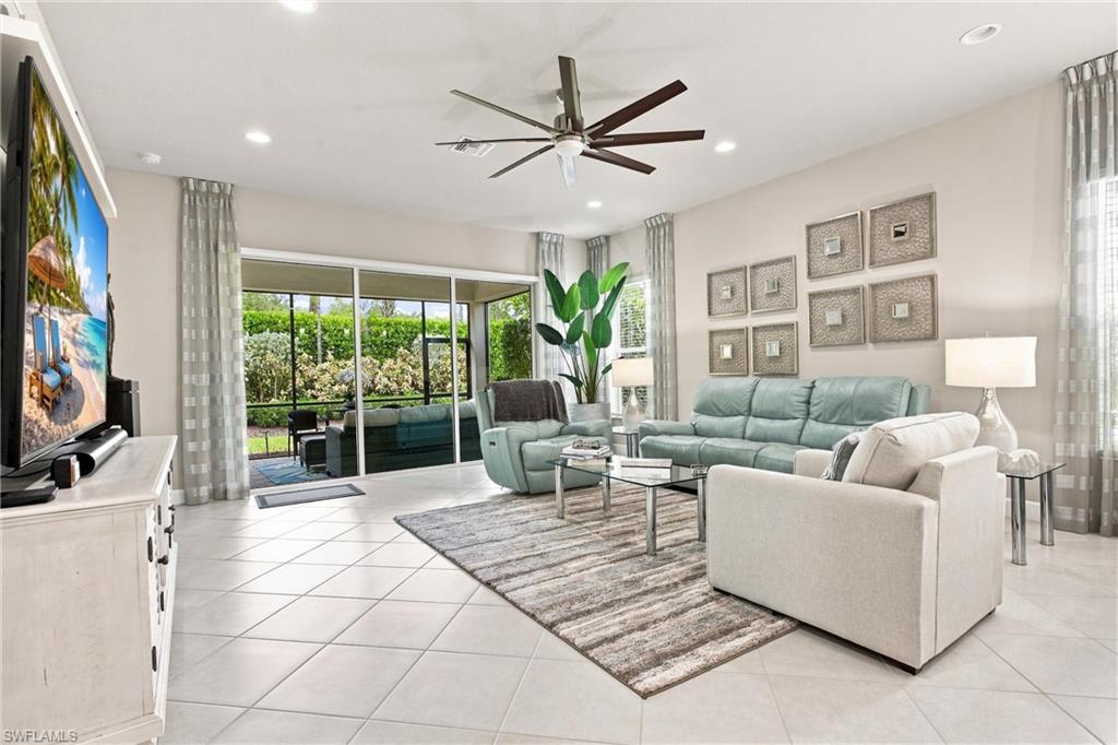 Spacious living area featuring large format tile flooring, recessed lighting, and a modern ceiling fan