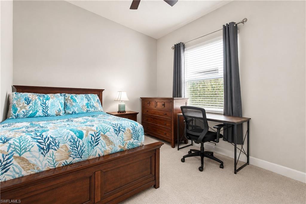 Neutral wall paint, ceiling fan, window with blinds, and light-toned carpet flooring