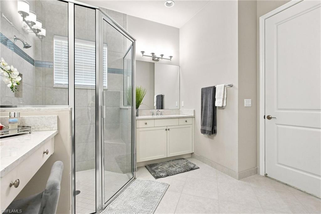 Glass-enclosed shower with tile surround and integrated bench