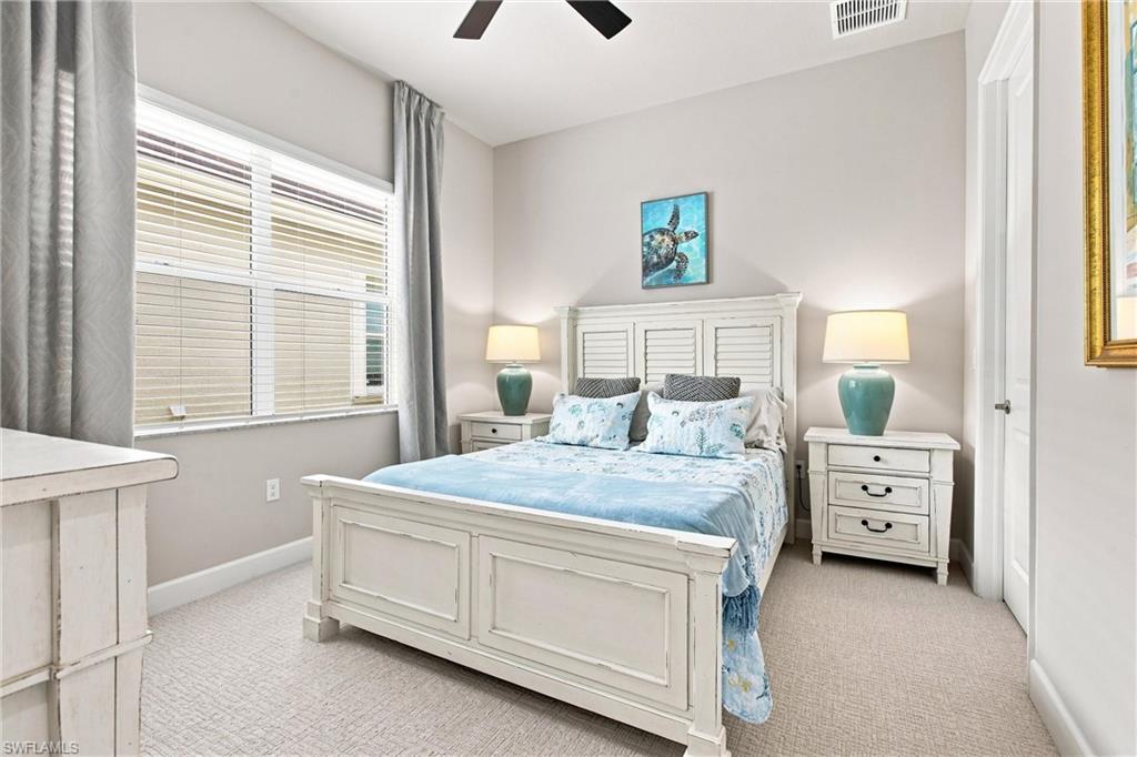 High ceilings complement the neutral wall tones and light-colored carpet flooring