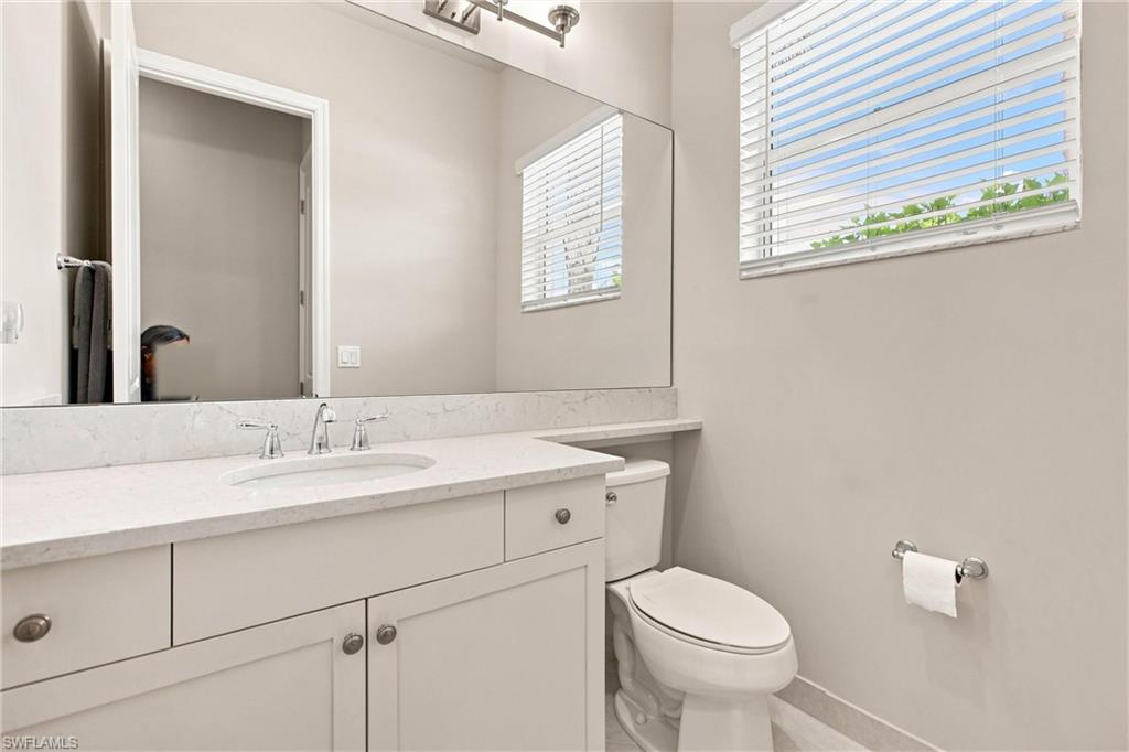 Vanity with stone-finish countertop, undermount sink, and chrome faucet