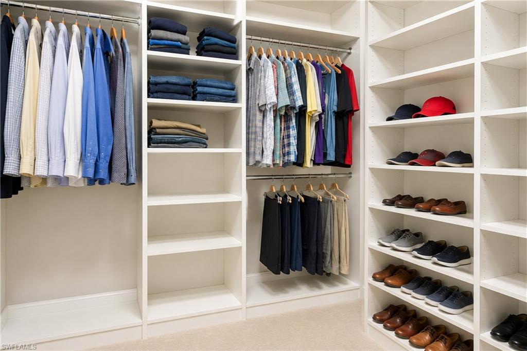 Custom closet system featuring multiple hanging rods, integrated shelving, and dedicated shoe storage
