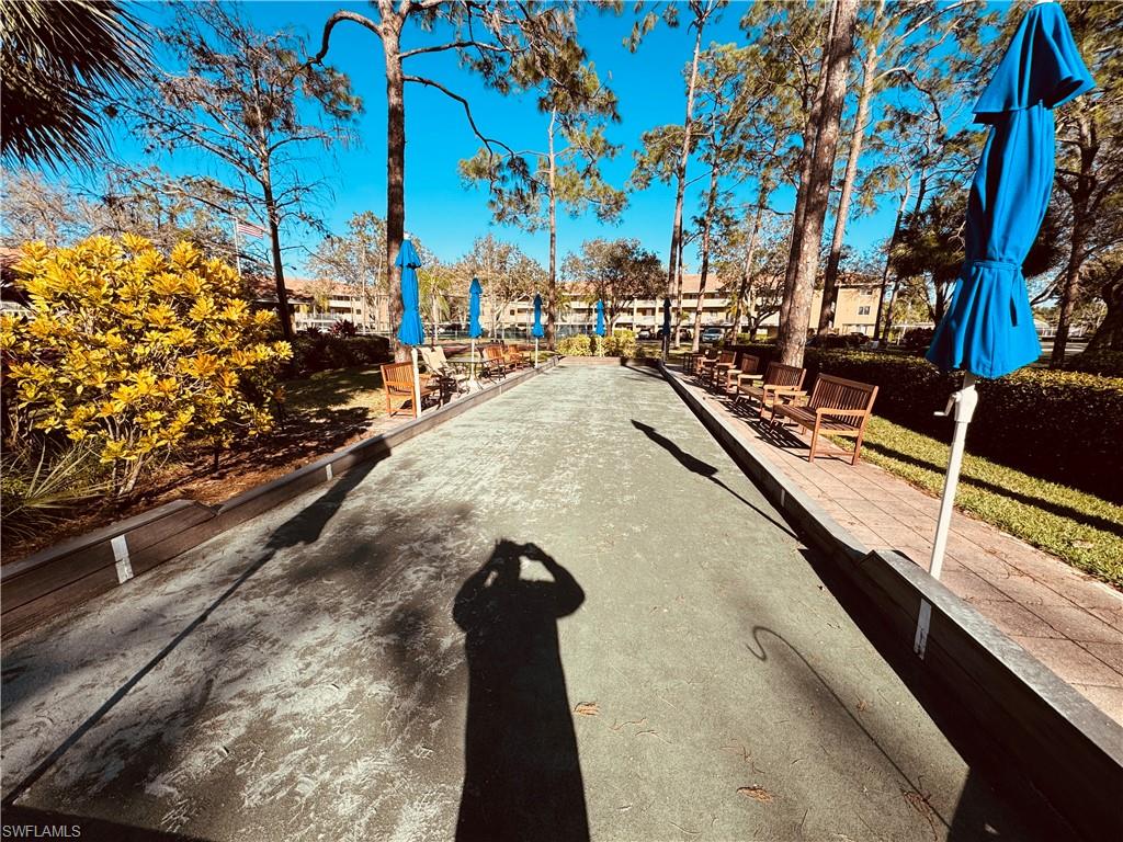 Bocce ball court featuring a dedicated playing surface, perimeter seating, and surrounding mature trees