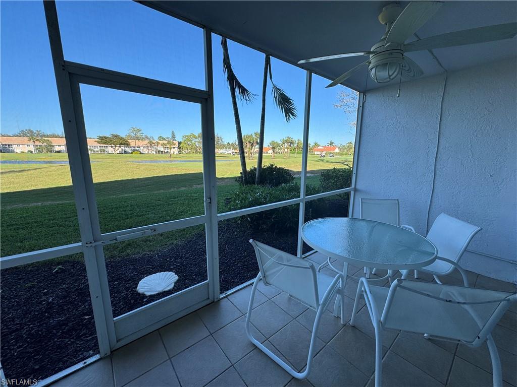 Screened patio with ceiling fan, tile flooring, and open-air backdrop