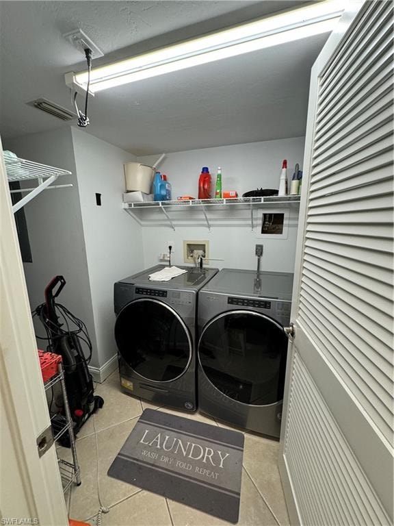 Laundry area featuring a louvered bi-fold door, wire shelving, and tiled flooring