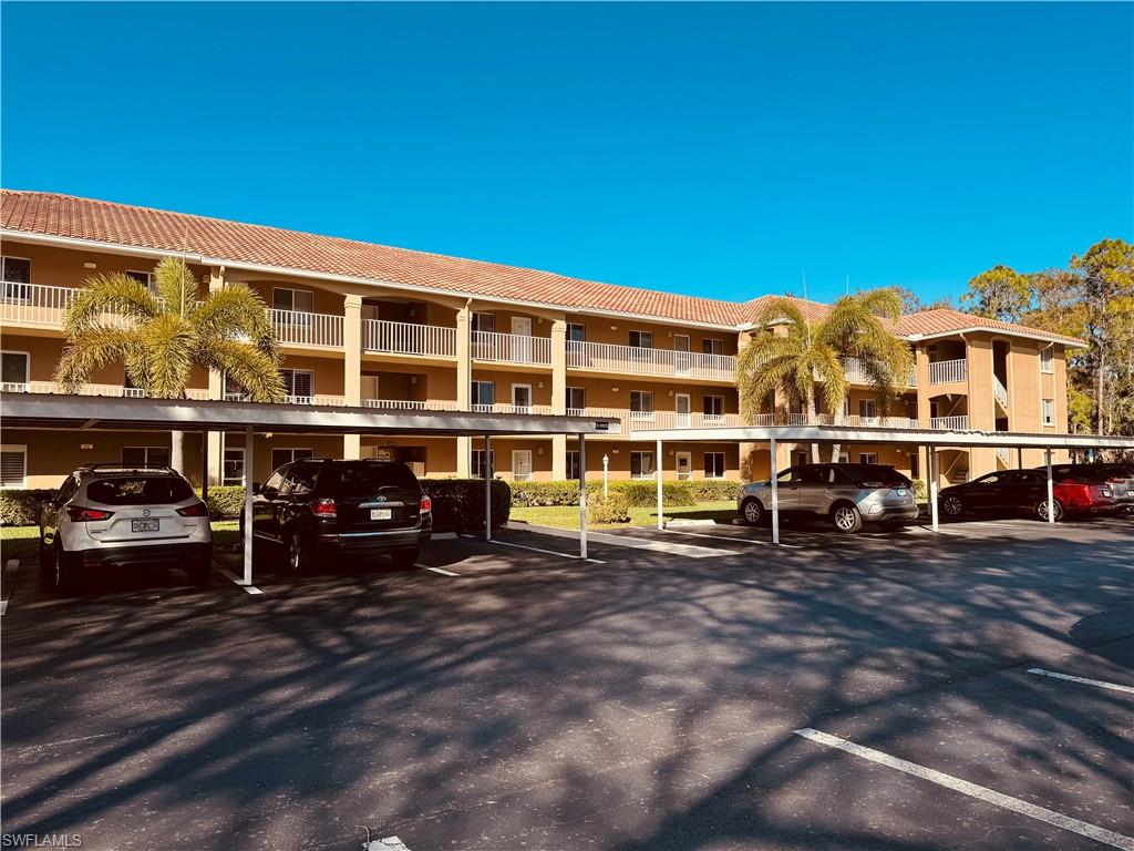 Multi-story building featuring balconies, a tile roof, and covered parking structures