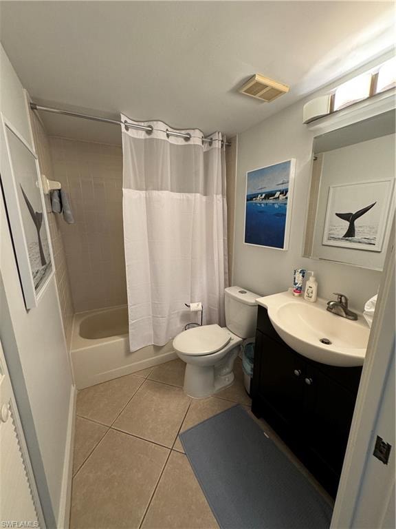 Recessed bathtub with shower, tiled flooring, vanity with integrated sink, and wall-mounted light fixture