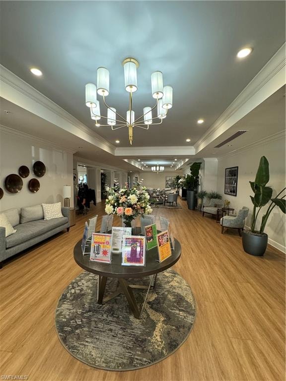 Recessed lighting, wood-finish flooring, crown molding, and a decorative chandelier