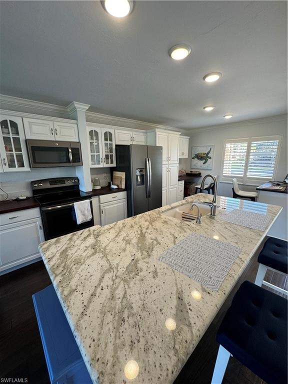 Kitchen featuring white cabinetry, an expansive island with a light-toned countertop, a built-in sink with a gooseneck faucet, and recessed lighting
