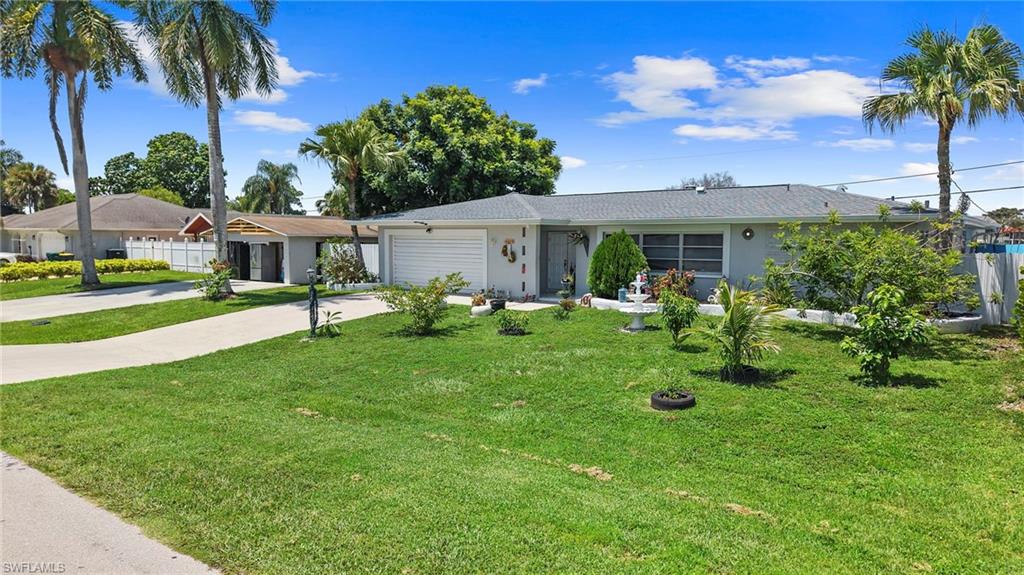 Single-story residence with a gray shingle roof, attached garage, and a front yard with mature landscaping