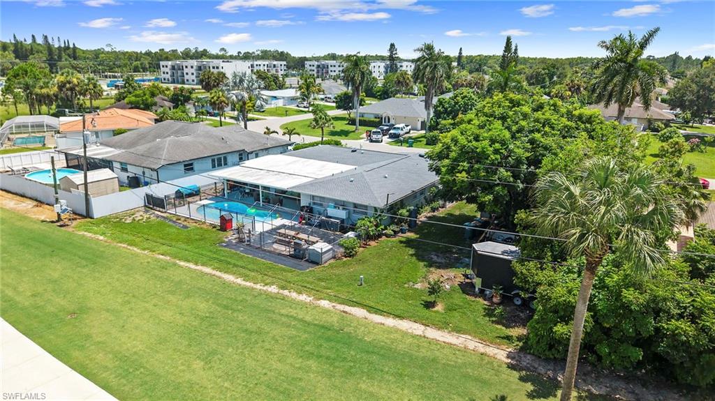 Expansive property featuring a screened-in swimming pool, a second enclosed pool, and a manicured lawn
