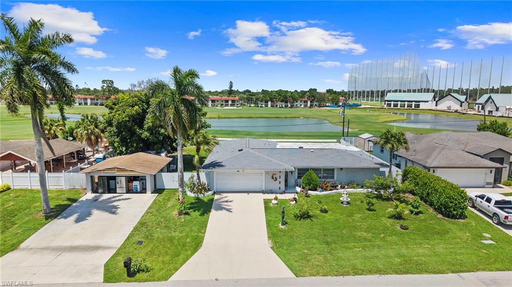 Expansive golf course backdrop, mature palm trees, lush green lawns, and a concrete driveway