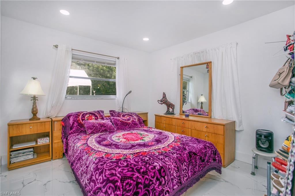 Recessed lighting, window with horizontal blinds, white walls, and light-toned flooring