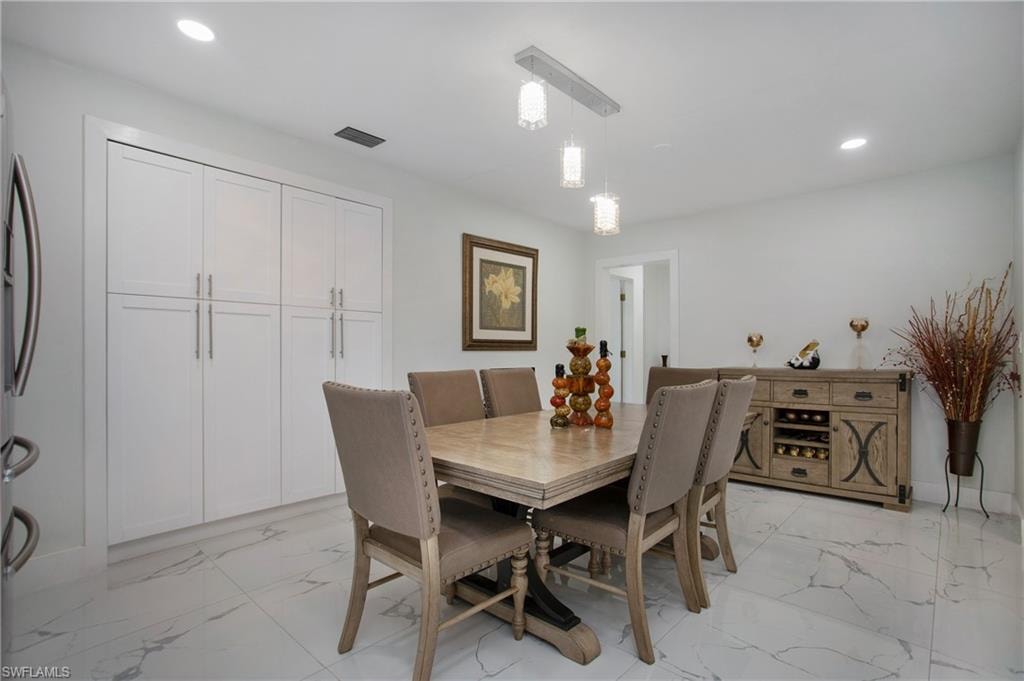 Recessed lighting, contemporary pendant light fixture, white shaker cabinetry, patterned tile flooring, built-in storage