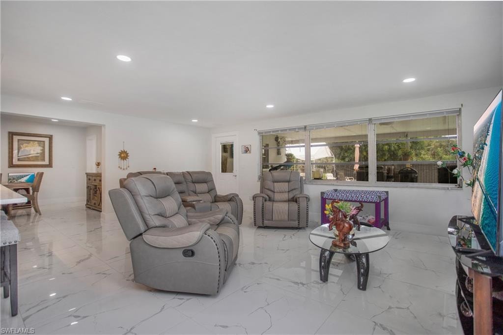 Recessed lighting illuminates the white walls and large format tile flooring throughout this open space