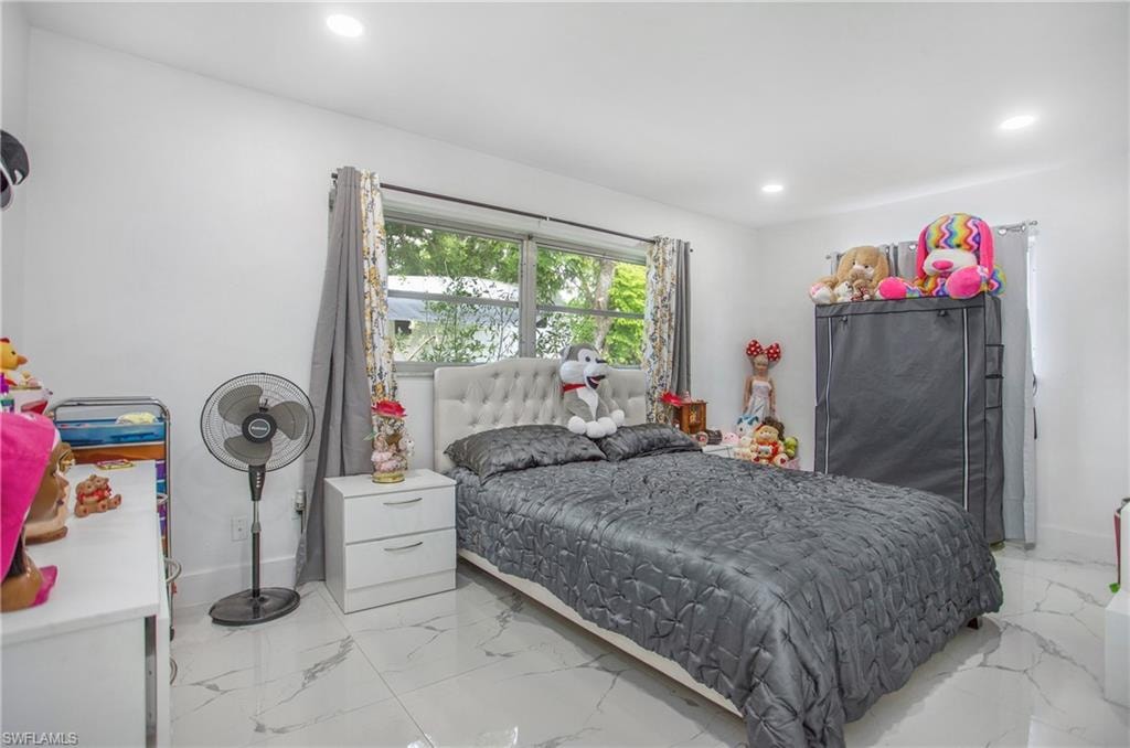 Recessed lighting illuminates this room featuring white walls and tile flooring