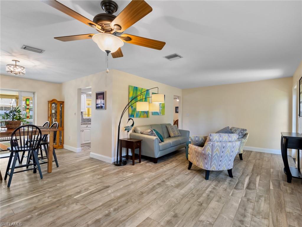 Dining area with sliders to the lanai; living room and entry to the right