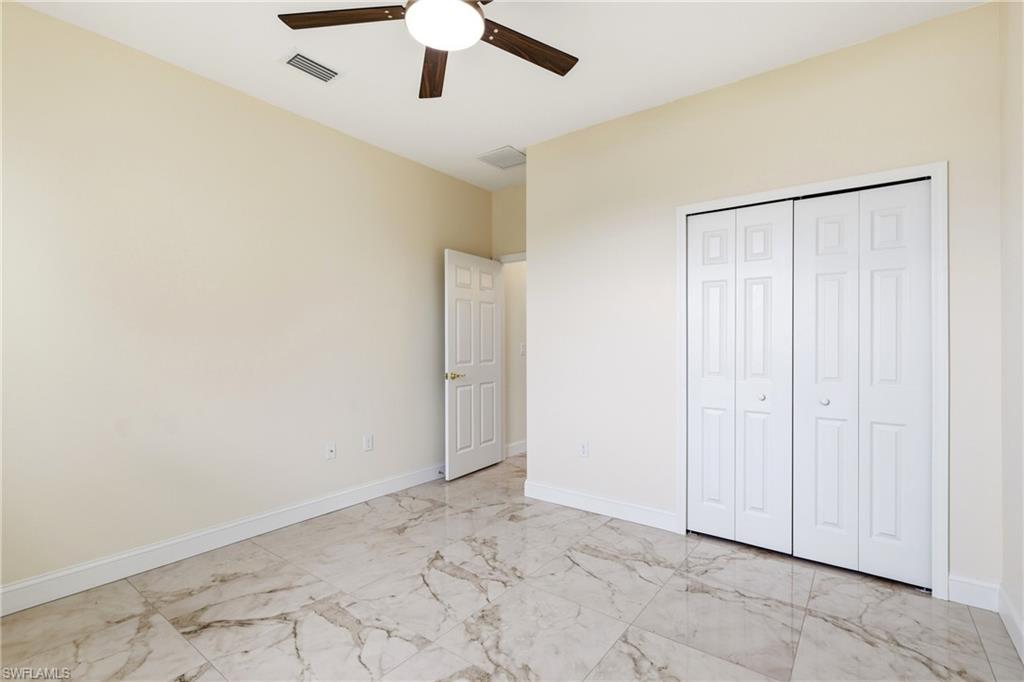 Room with light-toned walls, white trim, and a ceiling fan