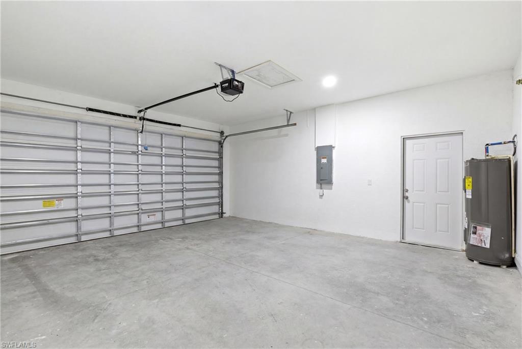 Attached garage featuring a concrete floor, automatic garage door opener, and a panel door