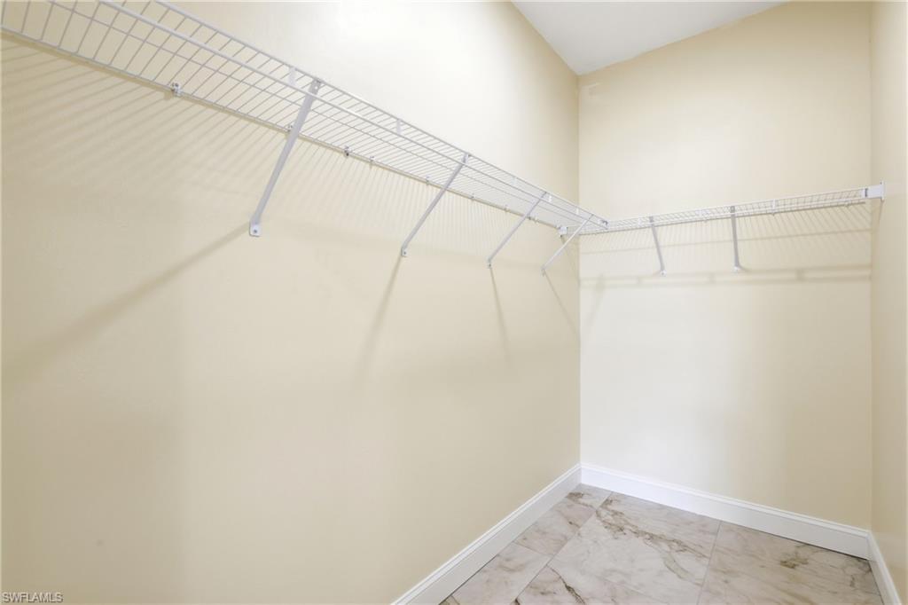 Walk-in closet with wire shelving system and tile flooring