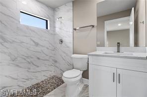 Full bath with vanity, a marble finish shower, and marble finish flooring