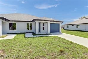 View of front facade with concrete driveway, a front lawn, an attached garage, and stucco siding