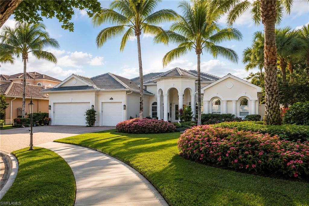 Stucco exterior with an arched portico entry, dual garage doors, and a tiled roof