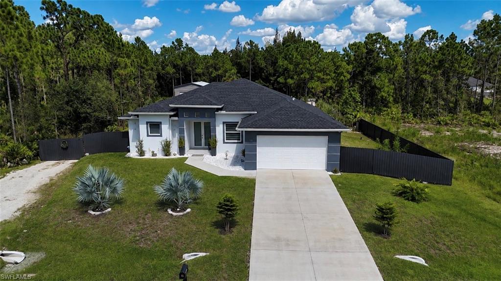 Contemporary exterior with a dark shingle roof, attached garage, and a concrete driveway