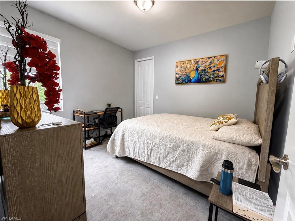 Light gray wall paint, recessed lighting, white window blinds, white bi-fold closet doors, and light-toned tile flooring