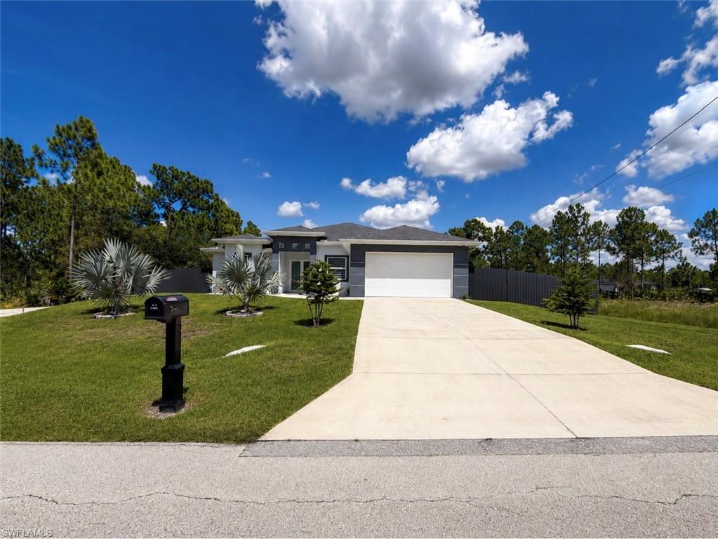Modern exterior with a light gray and white facade, attached garage, and concrete driveway