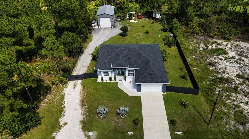 Single-story residence with an attached garage, paved driveway, and dark shingle roof