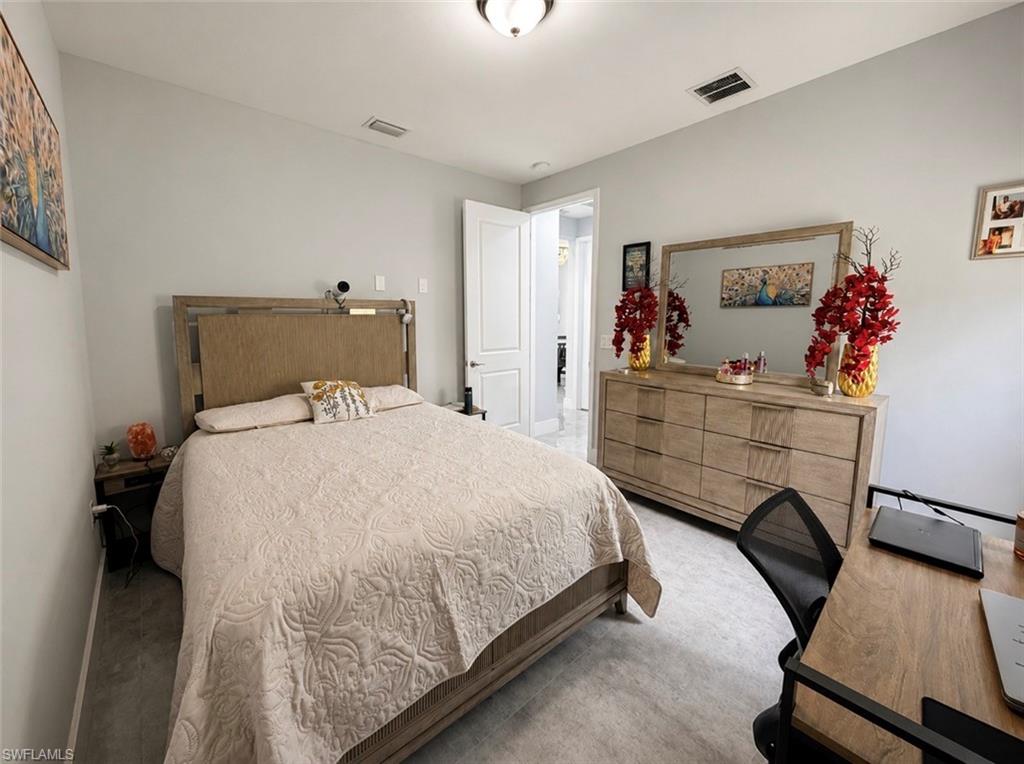 Light gray wall paint, light-toned wood-finish flooring, recessed ceiling light fixture, and a white interior door
