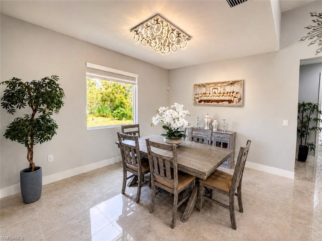 Recessed lighting, large window with roller shade, light-toned wall paint, decorative ceiling light fixture, polished tile flooring