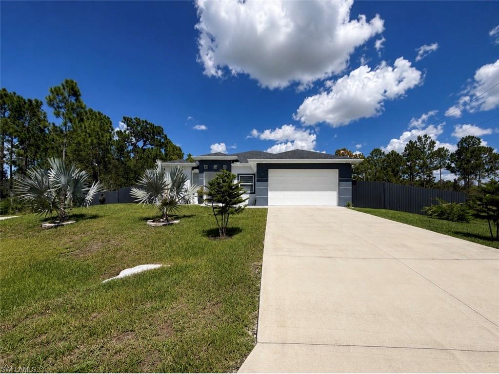 Contemporary exterior design with a two-car garage, concrete driveway, and mature landscaping