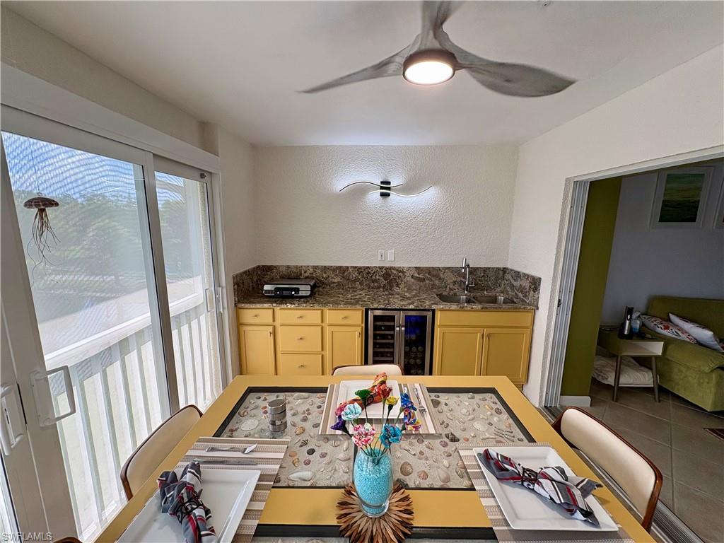 Outdoor kitchen with sink, wine refrigerator and portable grill.