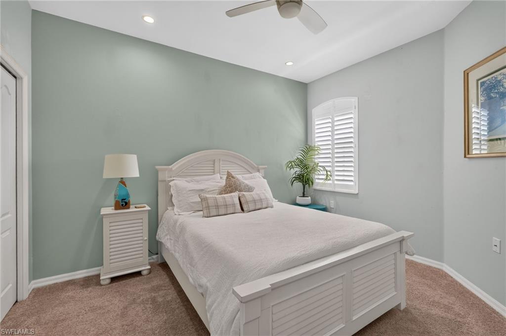 Recessed lighting, ceiling fan, arched window, plantation shutters, and carpeted flooring.