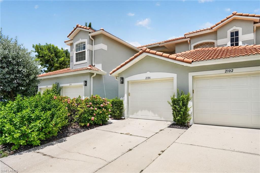 Mediterranean-style architecture with a tile roof,  and mature landscaping, stucco exterior.