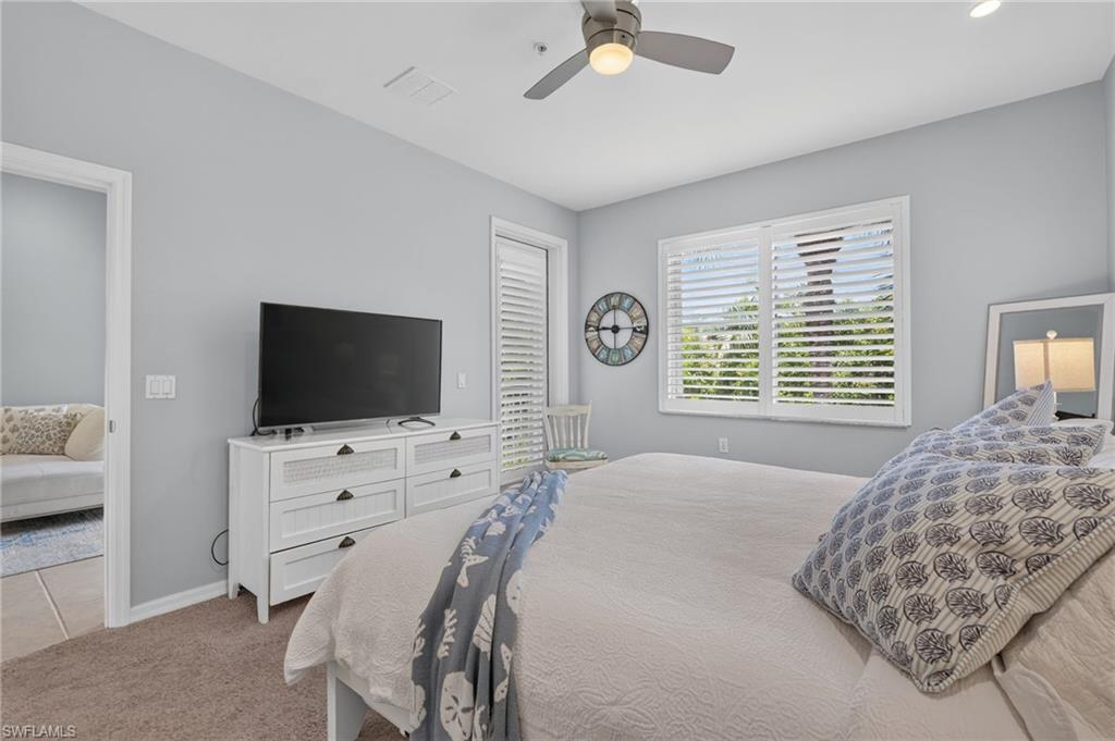 Window with plantation shutters, ceiling fan with integrated lighting, recessed lighting, and soft carpet flooring