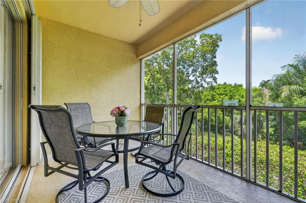 Screened balcony with textured wall finish and ceiling fan.
