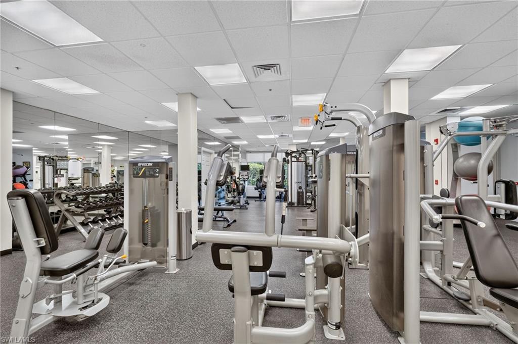 Fitness center with mirrored wall, recessed lighting, and resilient flooring