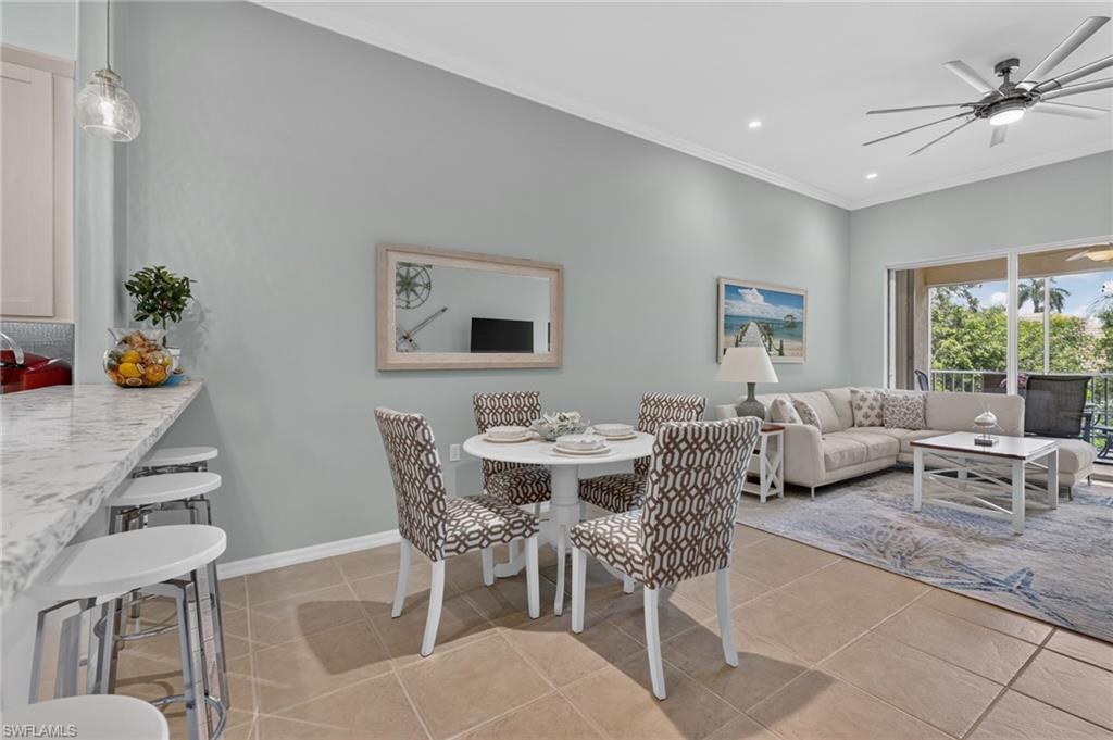 Tile flooring, crown molding, ceiling fan, sliding glass door, and recessed lighting.