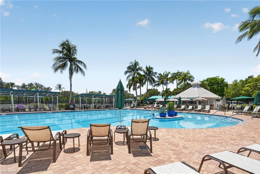 Expansive outdoor pool area with patterned paver decking, a free-form pool, and a circular poolside structure