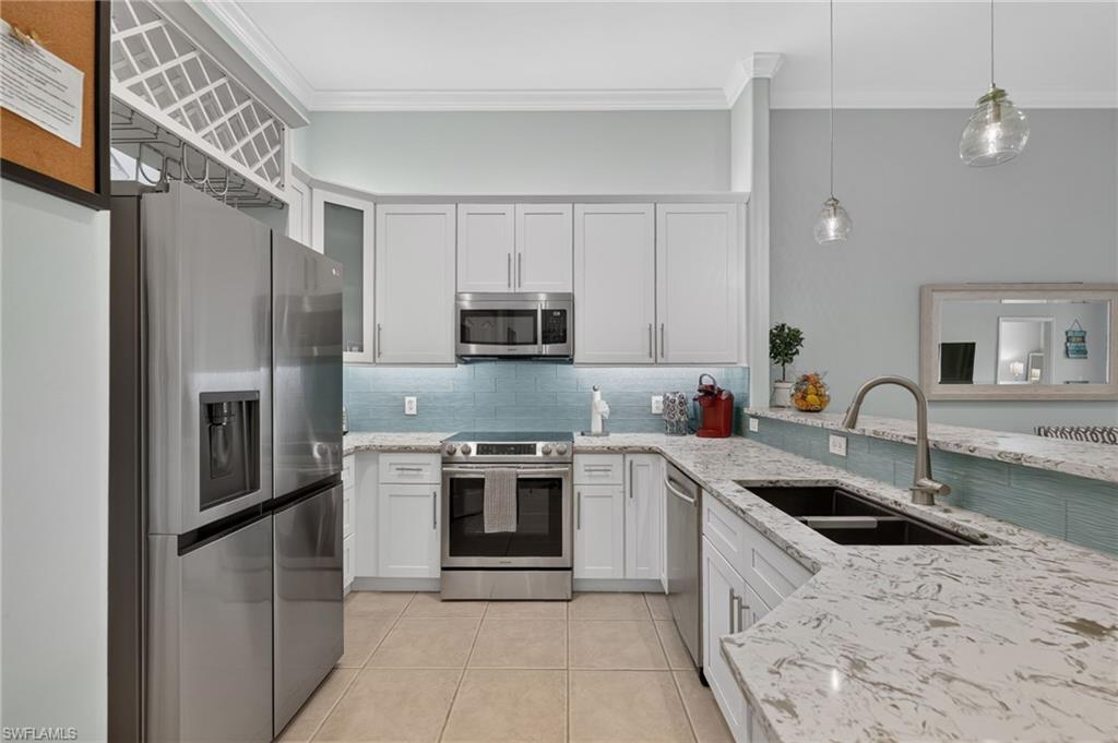 Kitchen featuring stainless steel appliances, white cabinetry, a tiled backsplash, white countertops, and recessed lighting.
