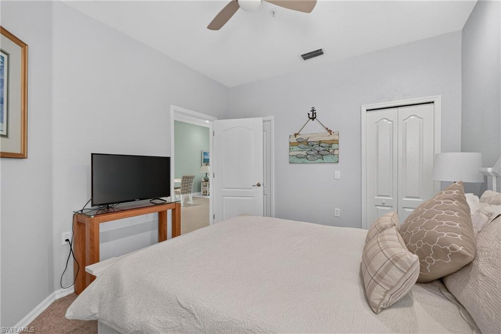 Ceiling fan, painted walls, carpet flooring, interior doors, and built-in closet with bi-fold doors.