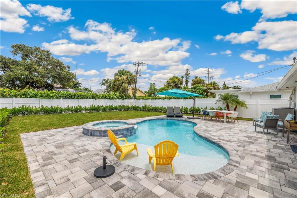View of swimming pool with a patio and an in ground hot tub