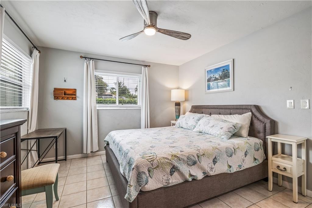 Tiled bedroom featuring ceiling fan