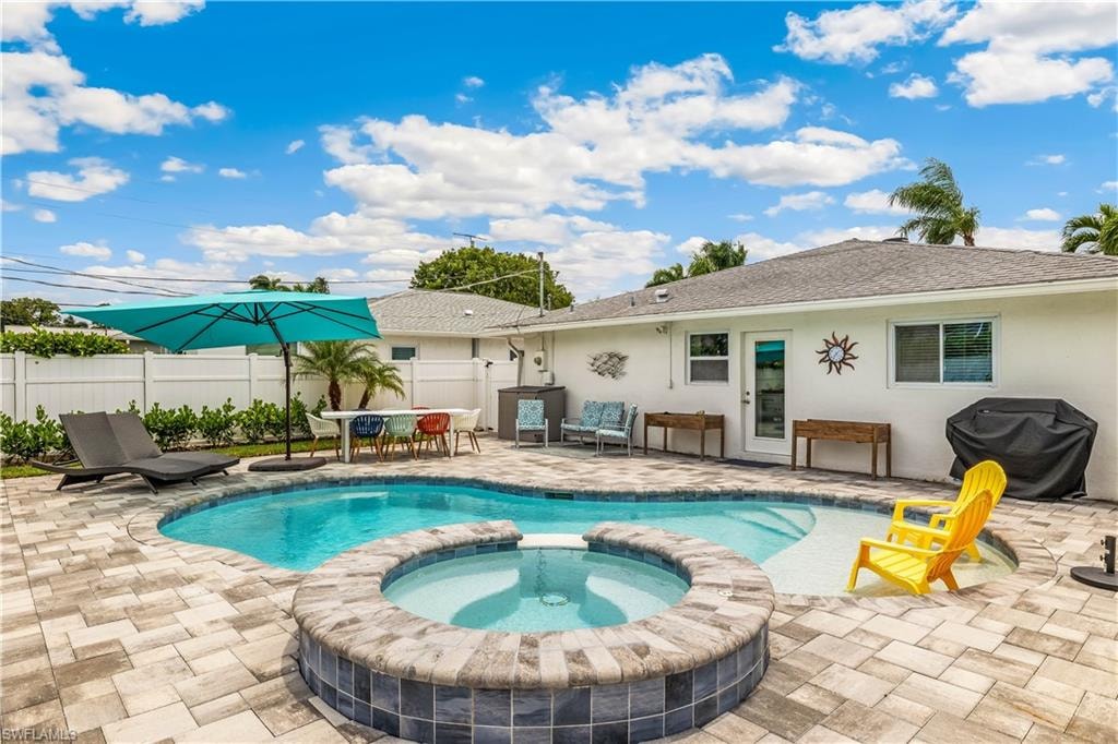 View of swimming pool with a grill, an in ground hot tub, and a patio
